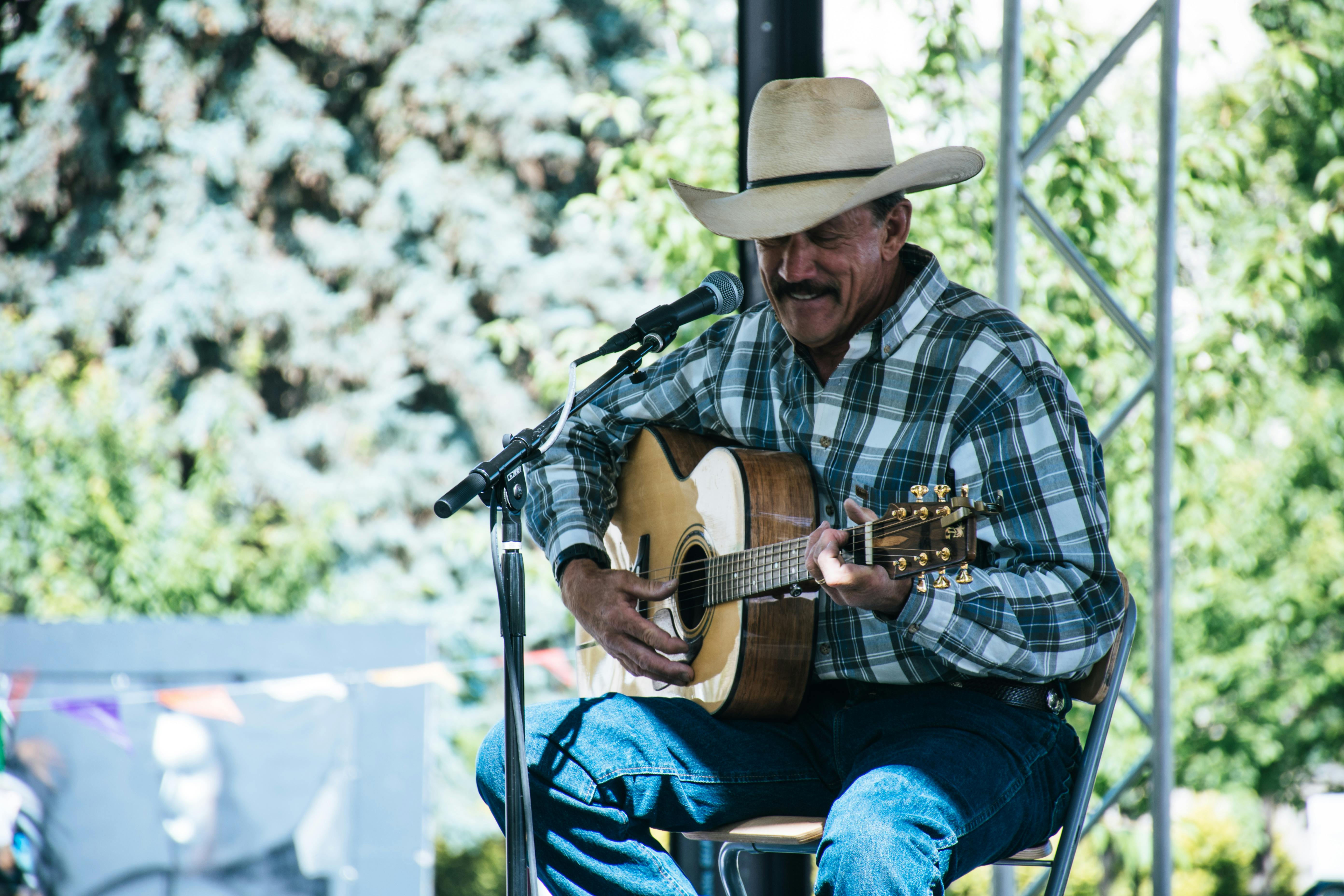 Country artiest met gitaar op een festivalpodium